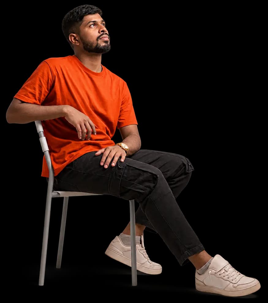 Nijan, in an orange tee, sitting on a chair and looking up